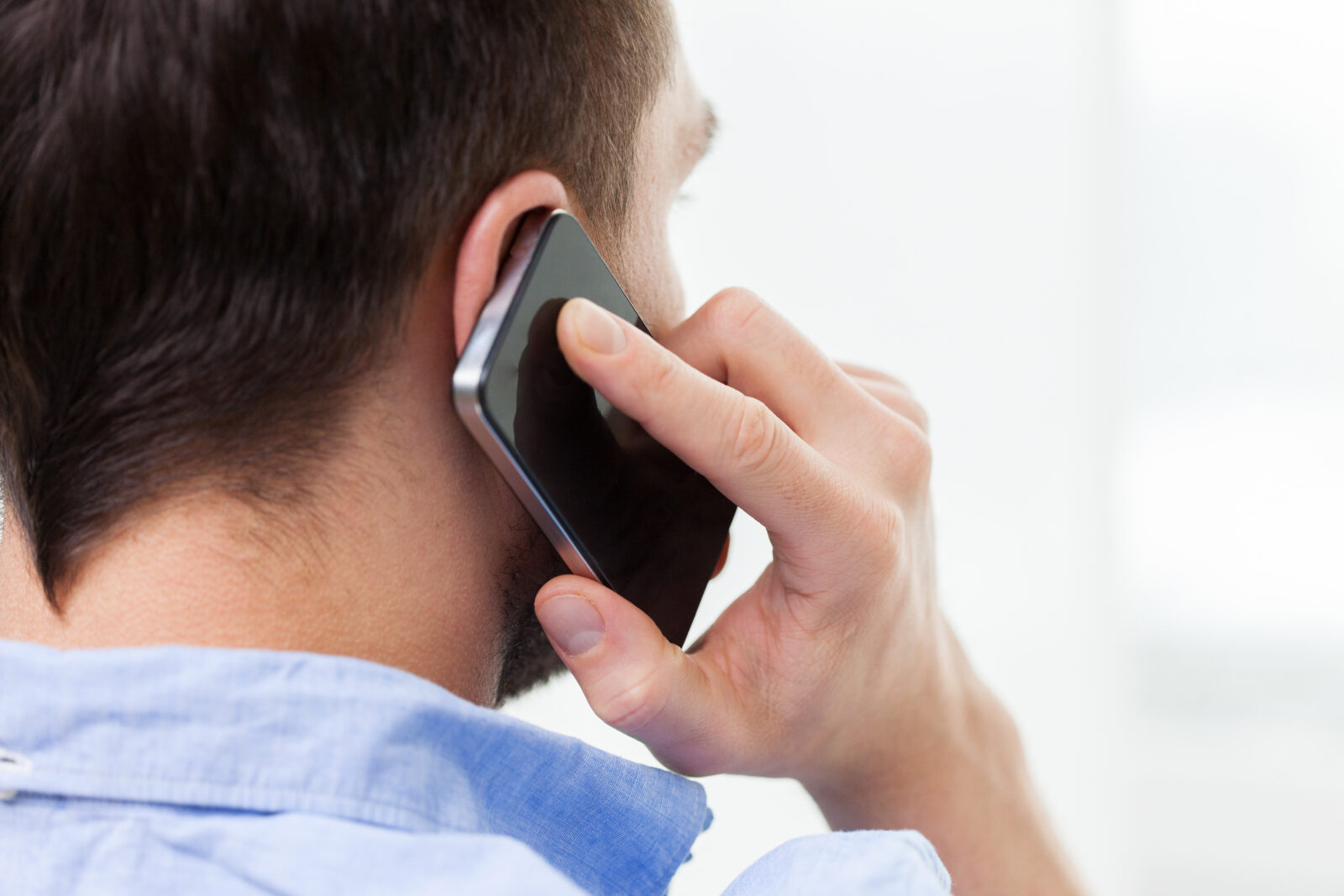 スマートフォンで電話予約の対応をしているイメージ