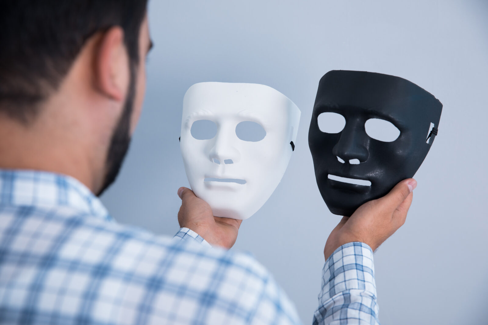白と黒の仮面を持つ男性のイメージ画像。表面の見せ方と本当の魅力のズレを考える記事用写真