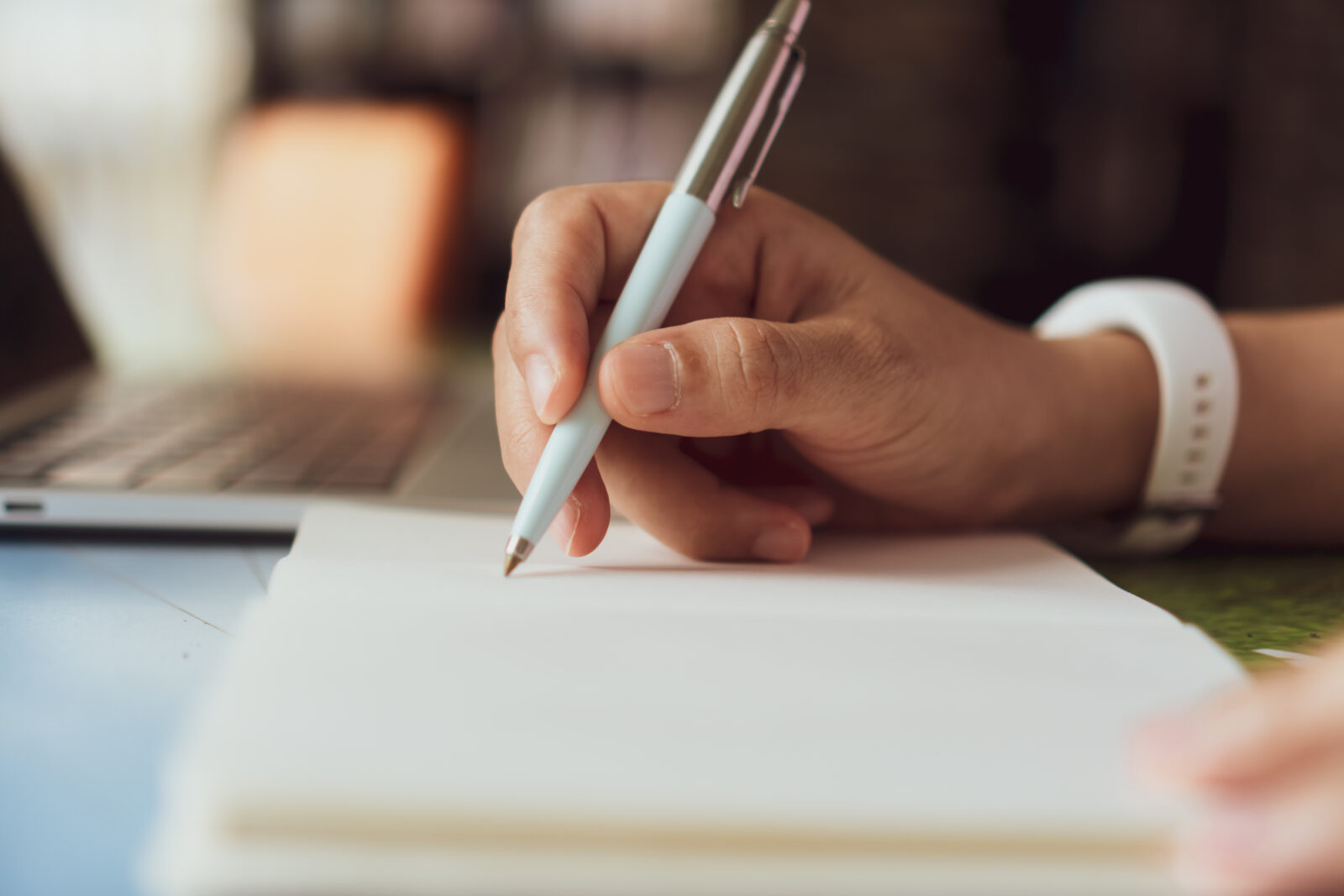 ノートに書き出しをする手元のイメージ画像。打ち出しや説明文を整理して見直す場面の写真