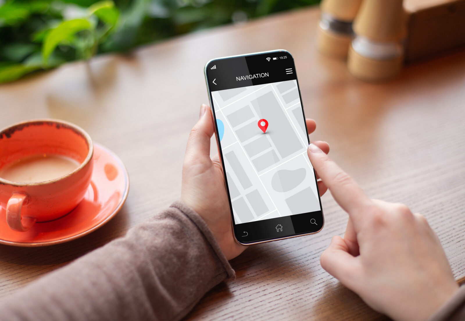 スマートフォンで地図アプリを見ながら場所を確認しているイメージ