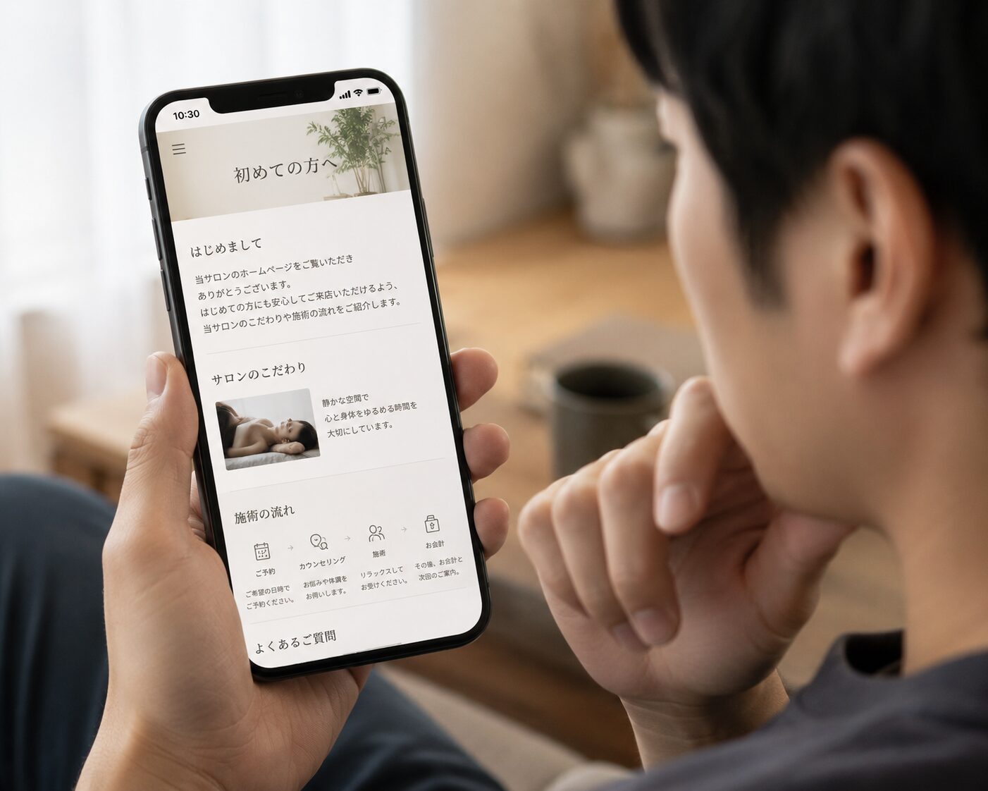 男性がスマホでサロンの初めての方向けページを確認しているイメージ画像