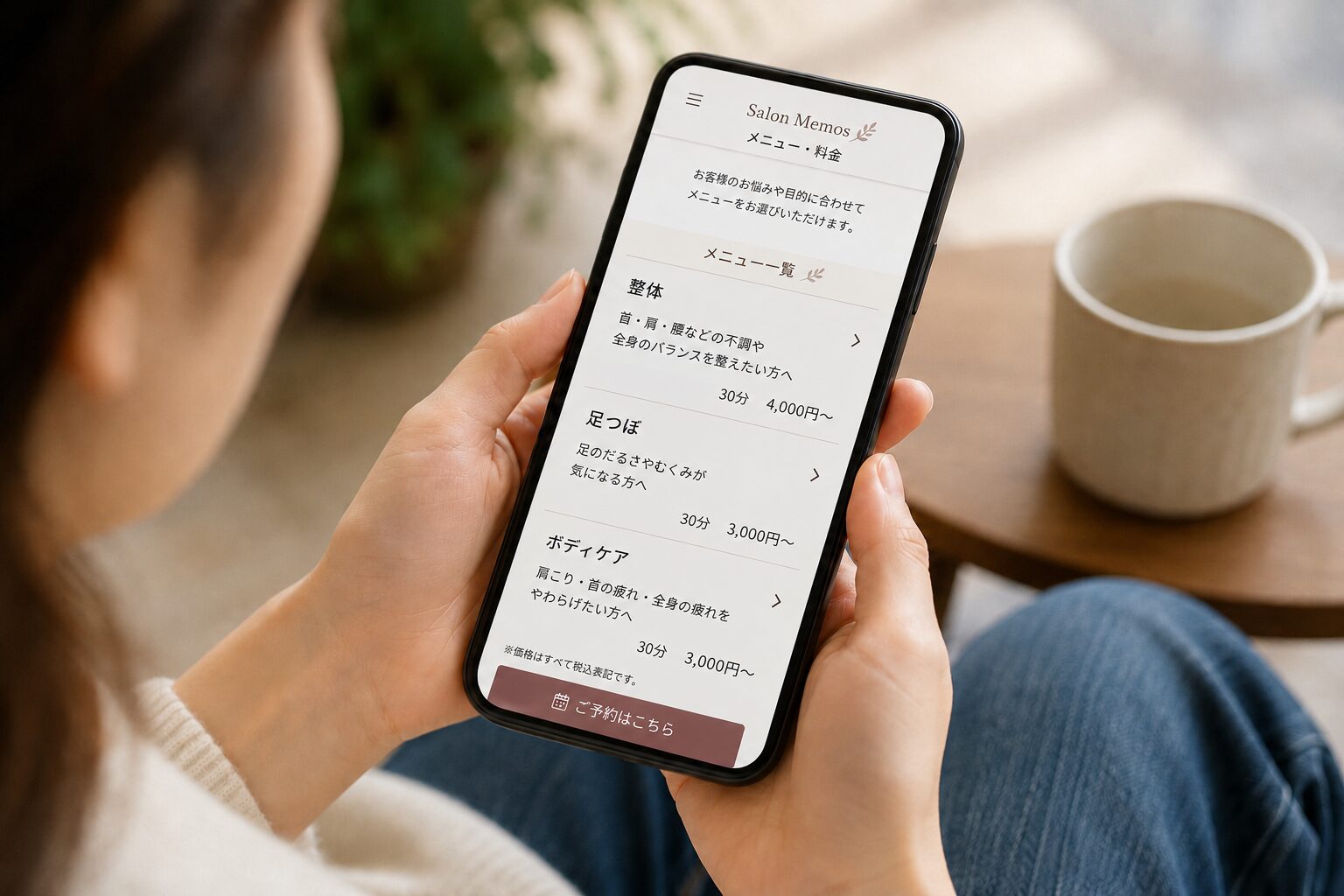 スマホでサロンのメニュー料金ページを確認しているイメージ